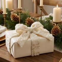 Itens Fita decorativa com detalhes em pele sintética, nas cores creme e dourado, com 25 mm de largura e 15 m de comprimento.